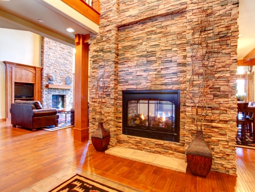 Beautiful stone wall with built-in fake fireplace. Two vases with dry branches complete the wall look